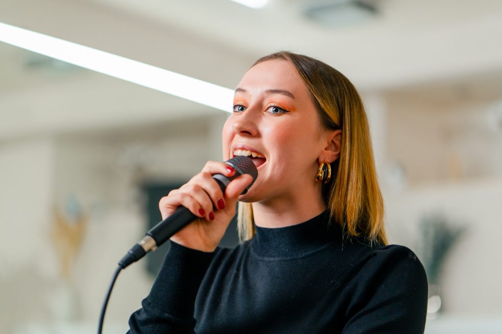 young girl sings in a vocal lesson with a microphone in her hands during a lesson at a music school